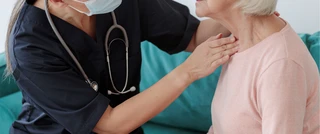 Enfermera palpando el cuello de un paciente