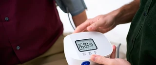 Doctor and patient interactions during a consultation involving a blood pressure check up.
