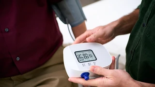 Doctor and patient interactions during a consultation involving a blood pressure check up.