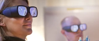 A woman wearing glasses, engaged in molecular diagnosis, focused on her task with a serious expression.