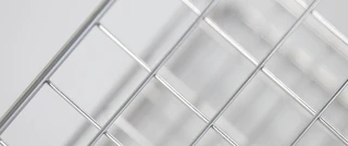 Close-up of a metal wire grid pattern, with diagonal intersecting lines creating a geometric design, conveying a sense of modern minimalism.