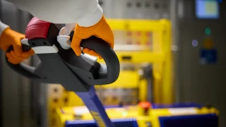 A close-up of a colleague pulling a trolly with machinery on.